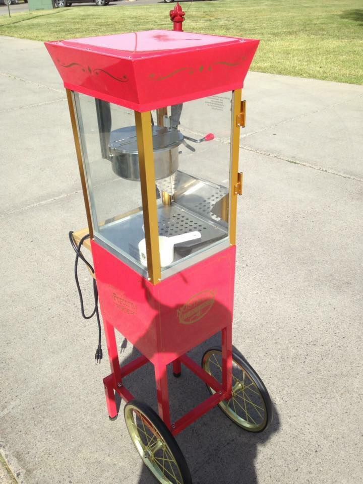 A red and gold popcorn machine on wheels