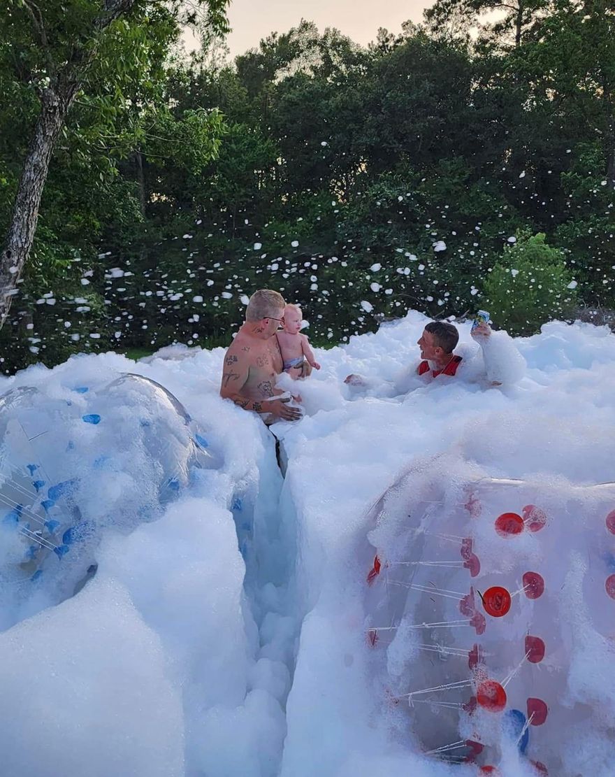 A group of people are playing in a pool of foam.