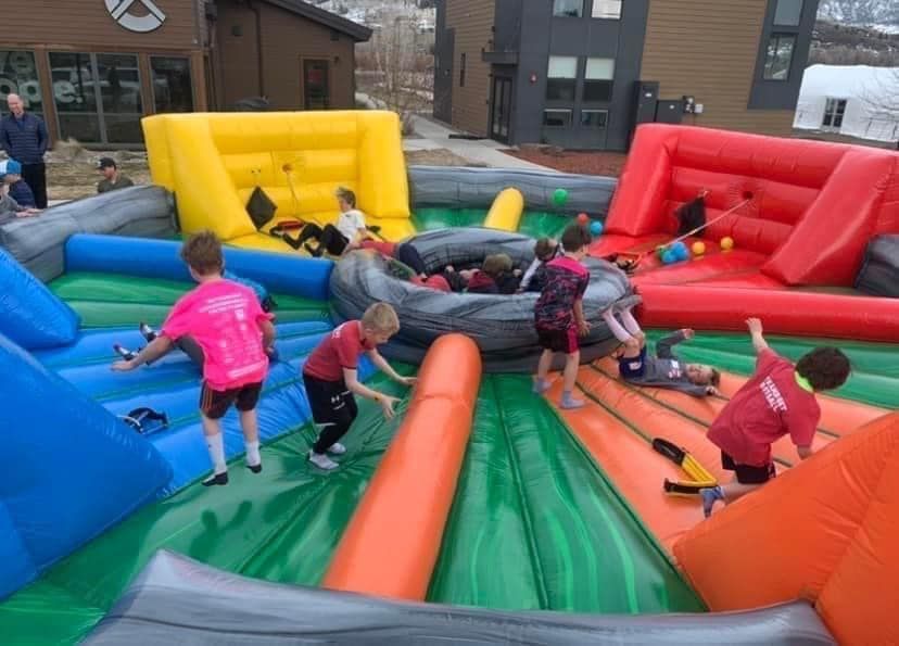 A group of children are playing on a large inflatable playground.