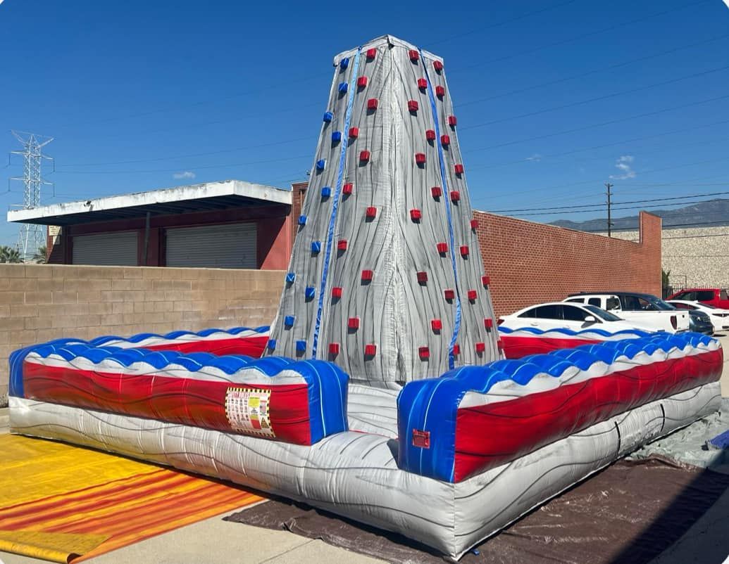 A large inflatable climbing wall is sitting on the side of the road.