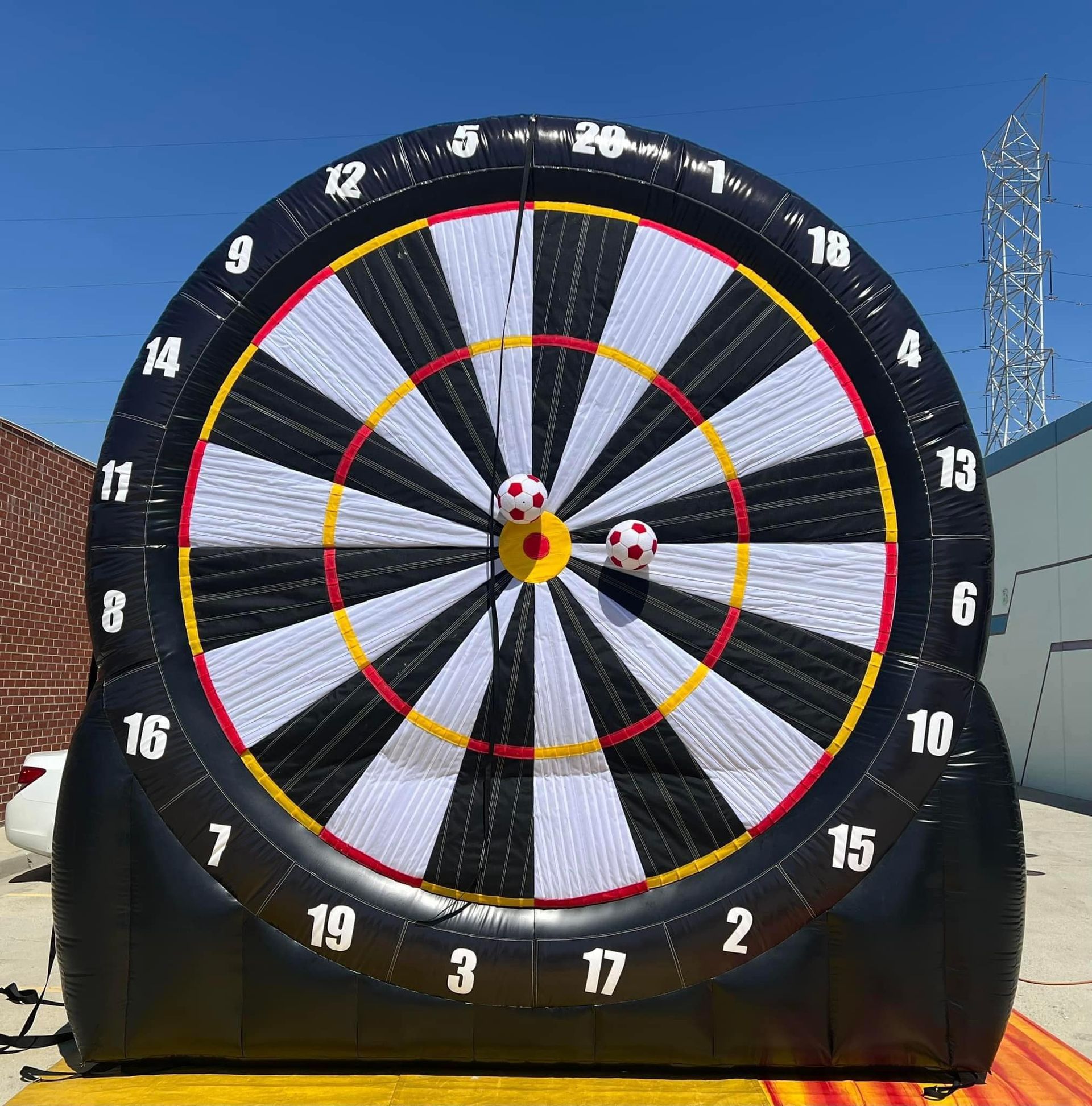 A large inflatable dart board with two soccer balls in the center
