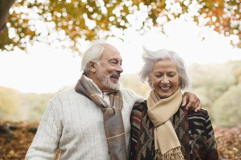 Shot of a happy senior couple in autumn. Wearing scarfs.