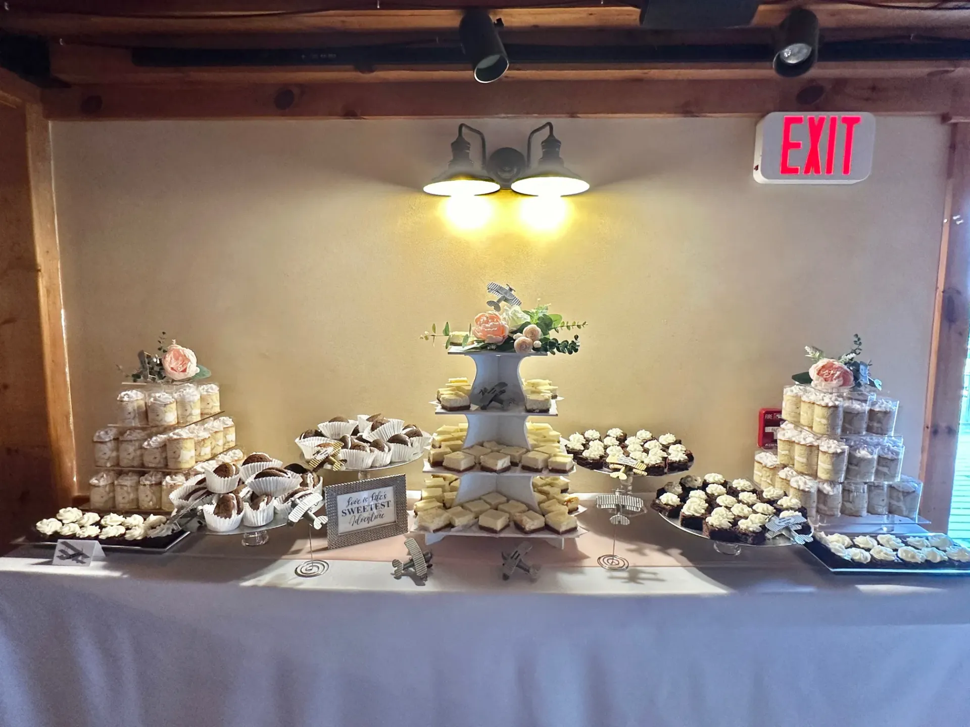 A table with a lot of cupcakes and a sign that says exit