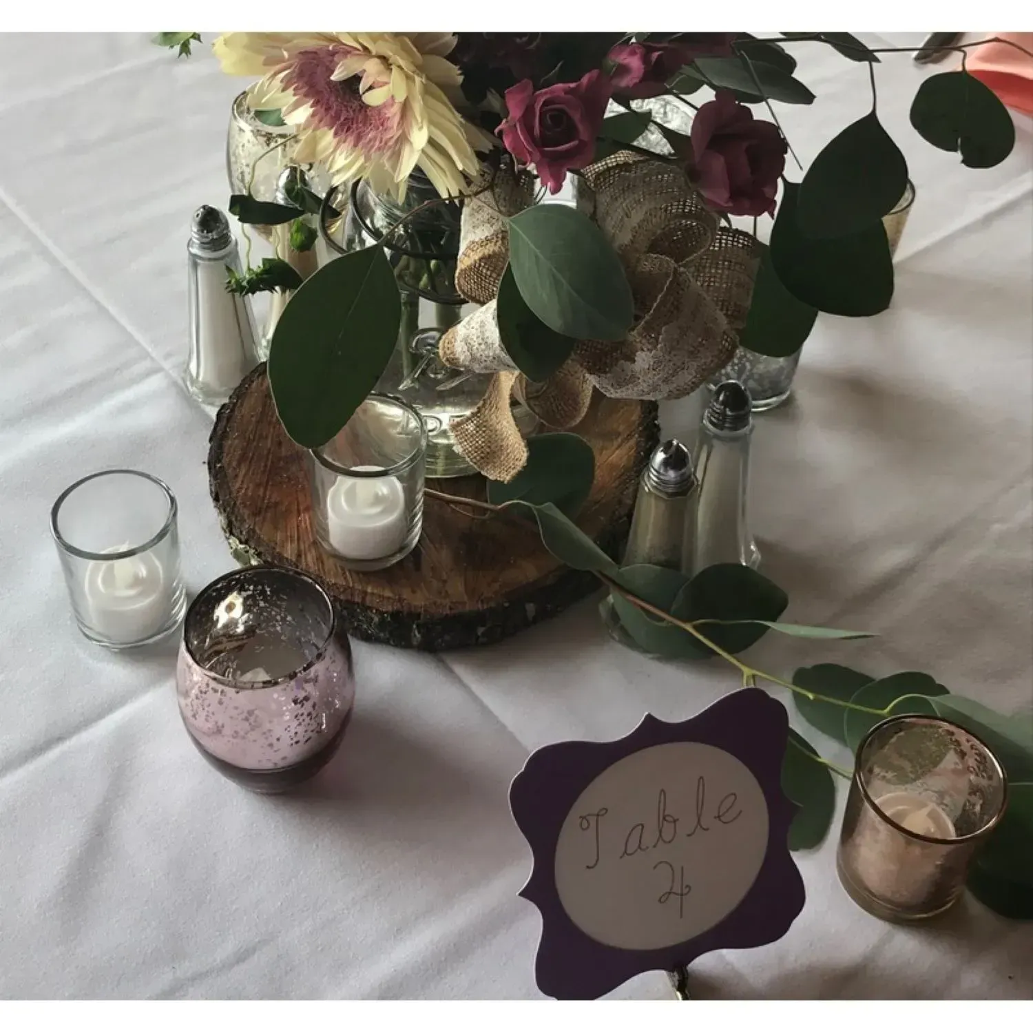 A table with flowers and candles and a table number 2