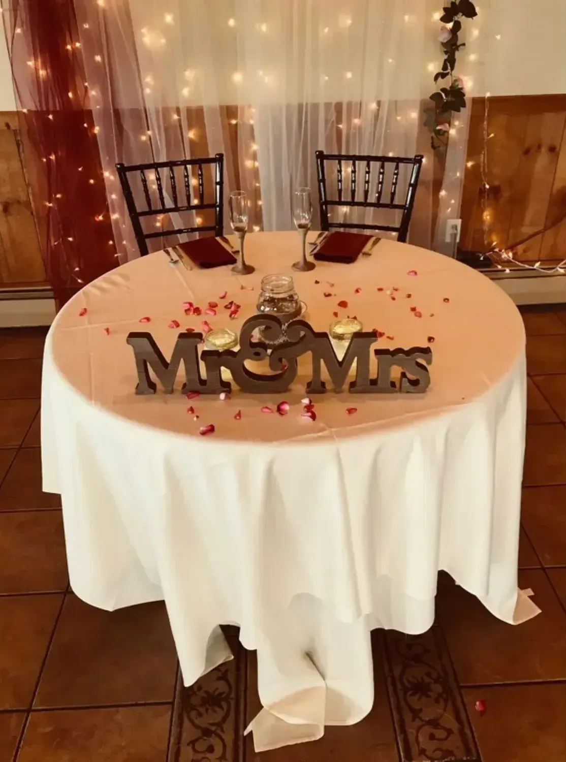 A table with a white tablecloth and a sign that says mr. and mrs.