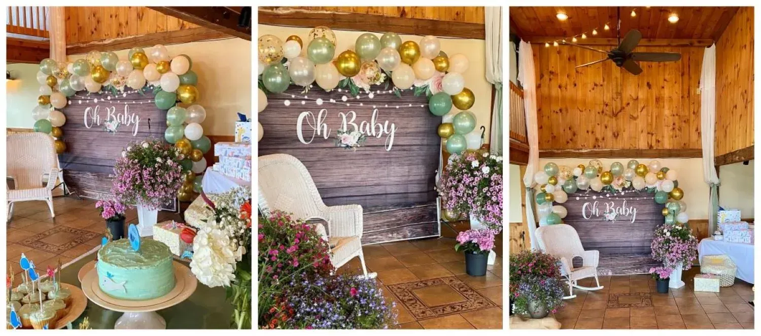 A room decorated for a baby shower with balloons , flowers , and a cake.