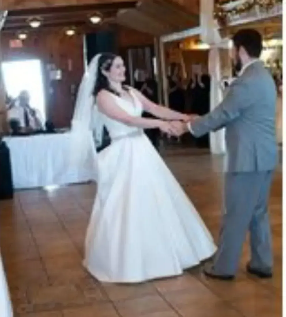 A bride and groom are dancing at their wedding reception