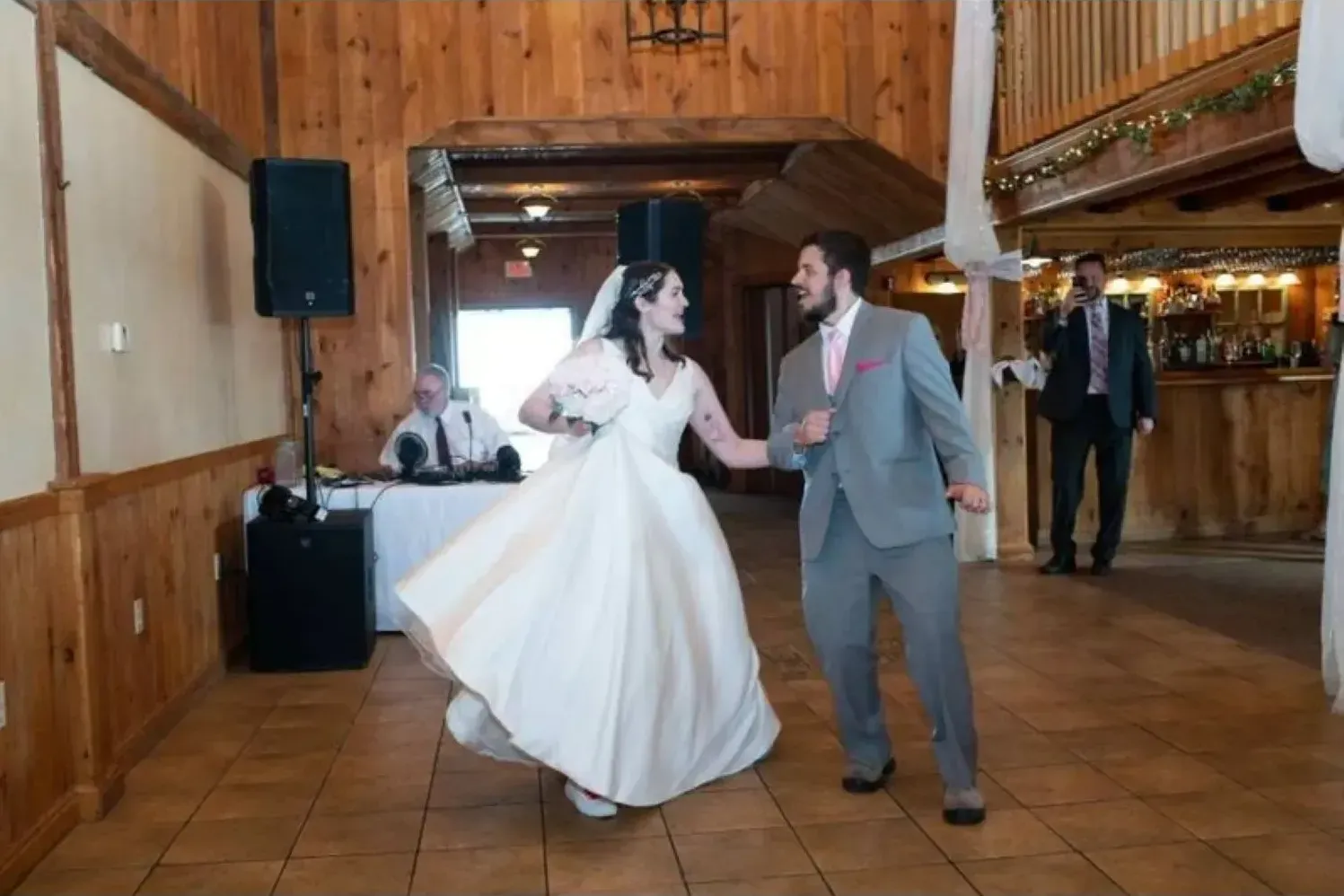 A bride and groom are dancing together at their wedding reception.