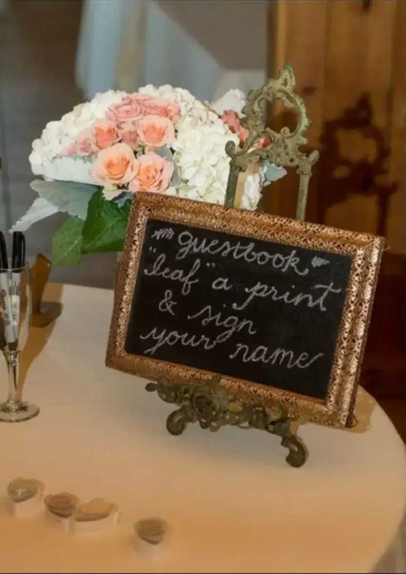 A sign on a table that says guestbook leaf a print and sign your name