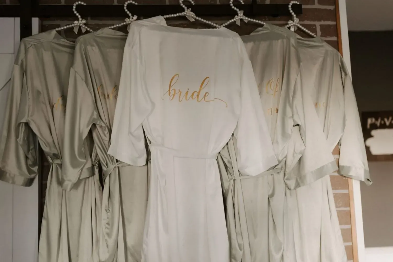 A group of bridesmaid robes hanging on a rack.