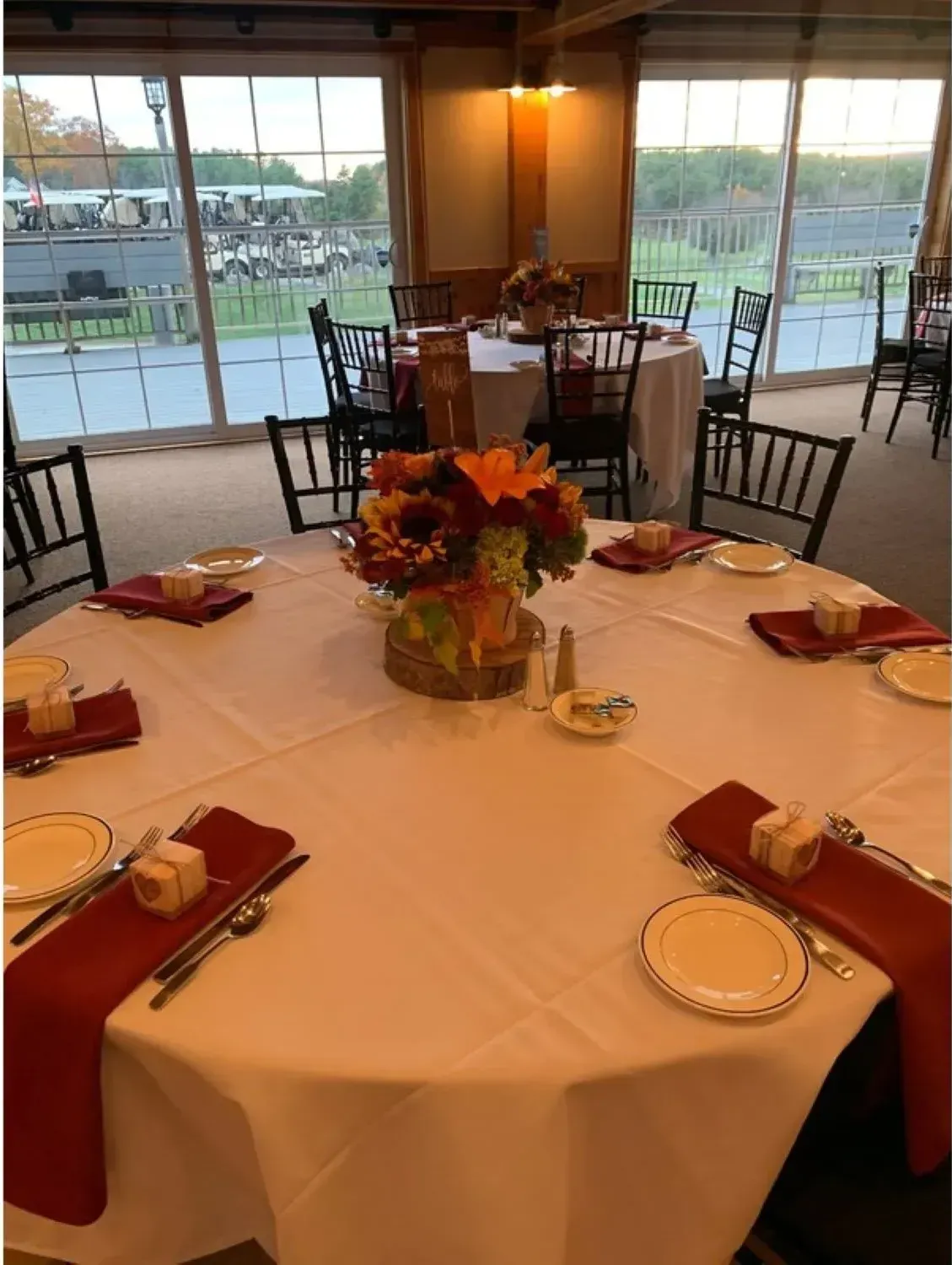 A table with plates , napkins , and a vase of flowers on it.
