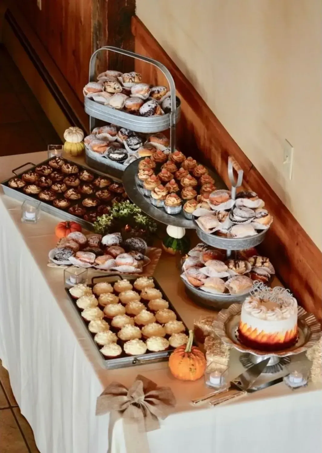 A table topped with a variety of desserts including cupcakes and a cake