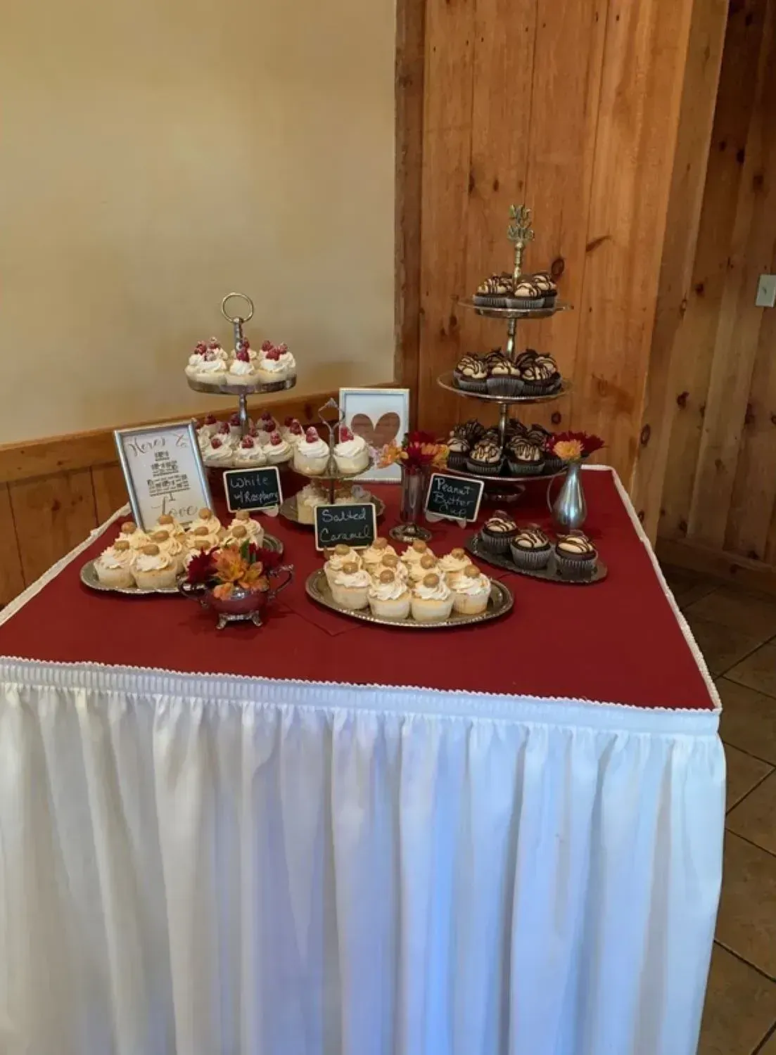 A table with cupcakes on it and a red table cloth.