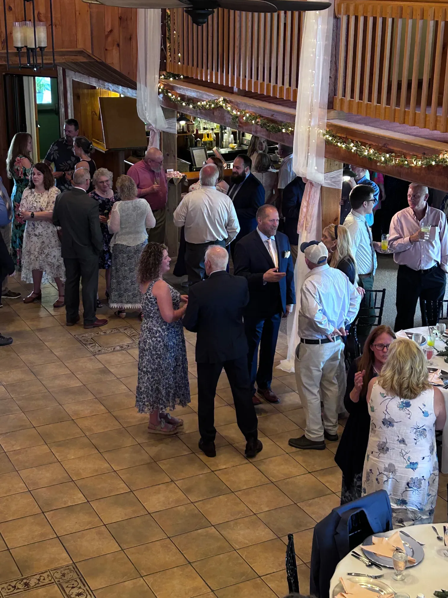 A group of people are standing in a room talking to each other.