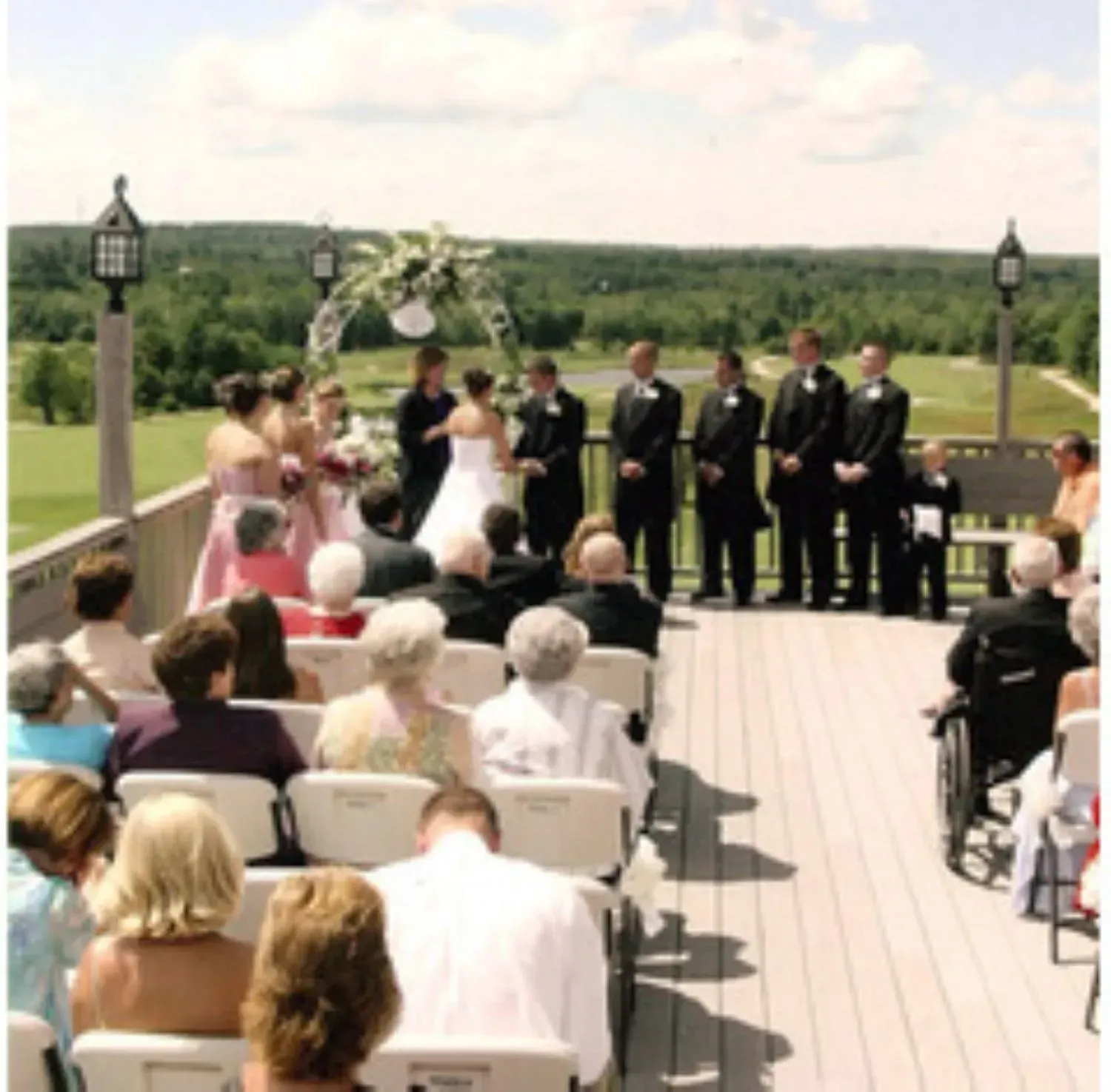 A group of people sitting in chairs watching a wedding ceremony