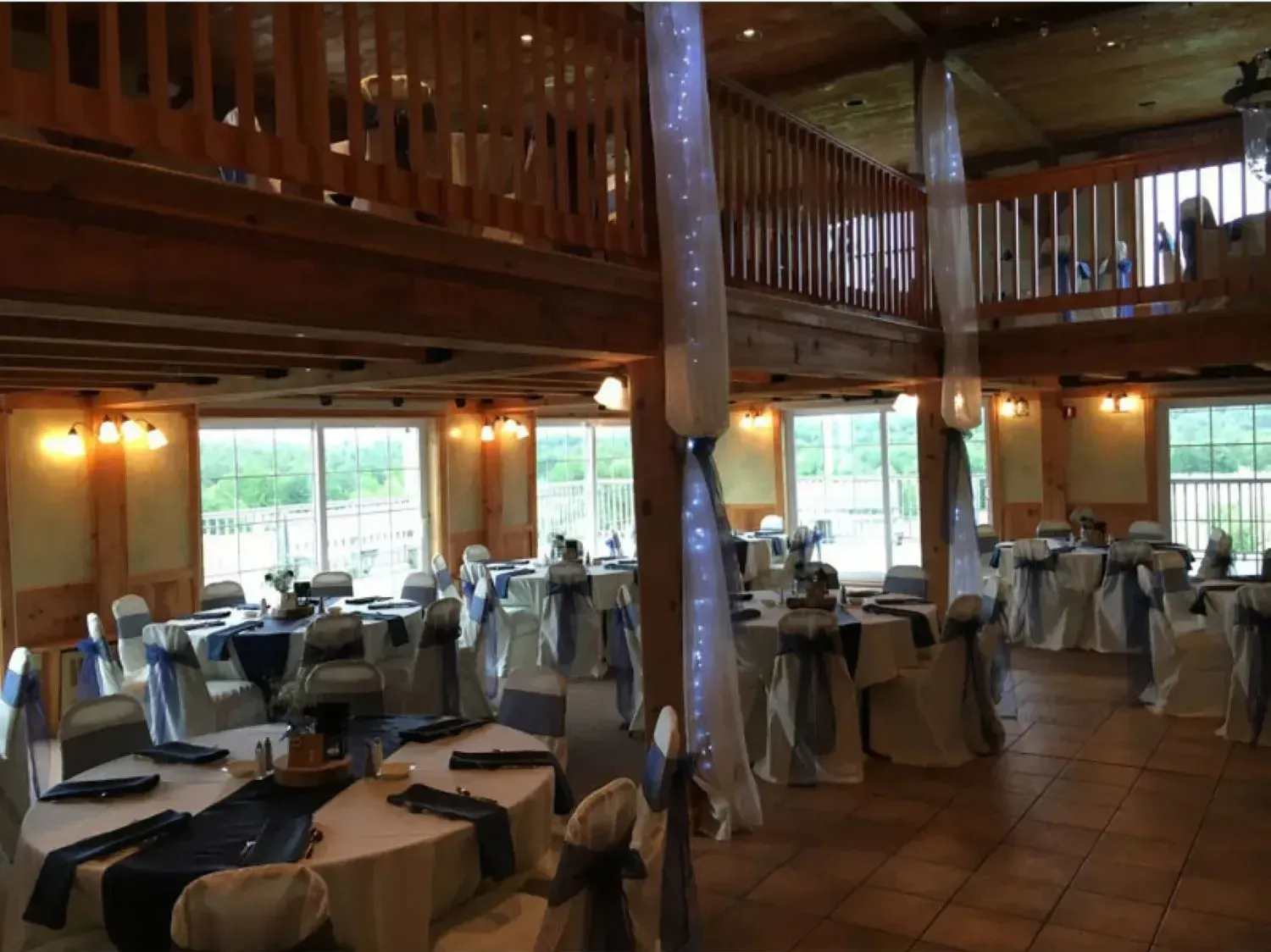 A large room with tables and chairs set up for a wedding reception.