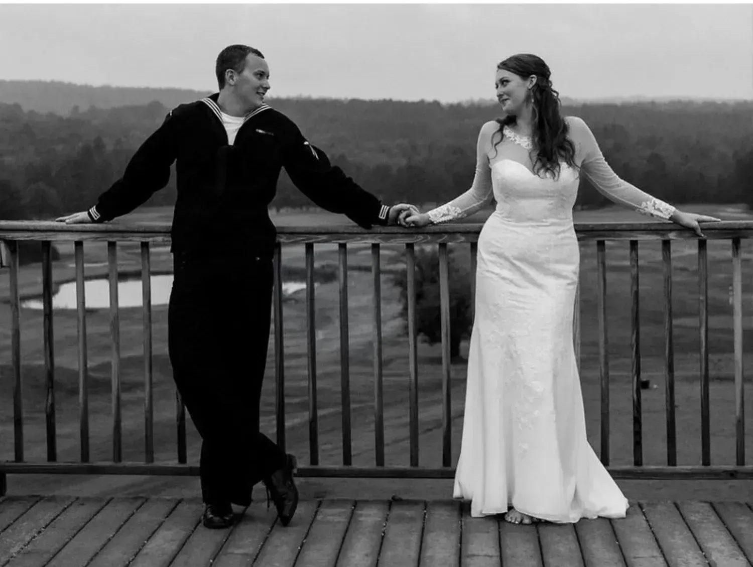 A black and white photo of a bride and groom holding hands