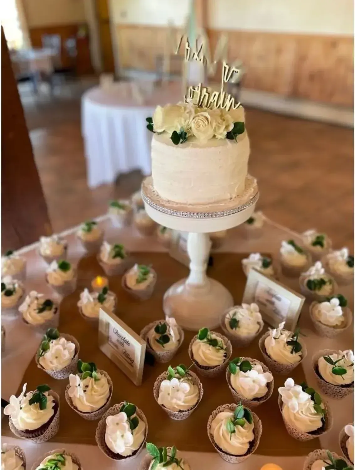 A table with cupcakes and a cake on top of it.