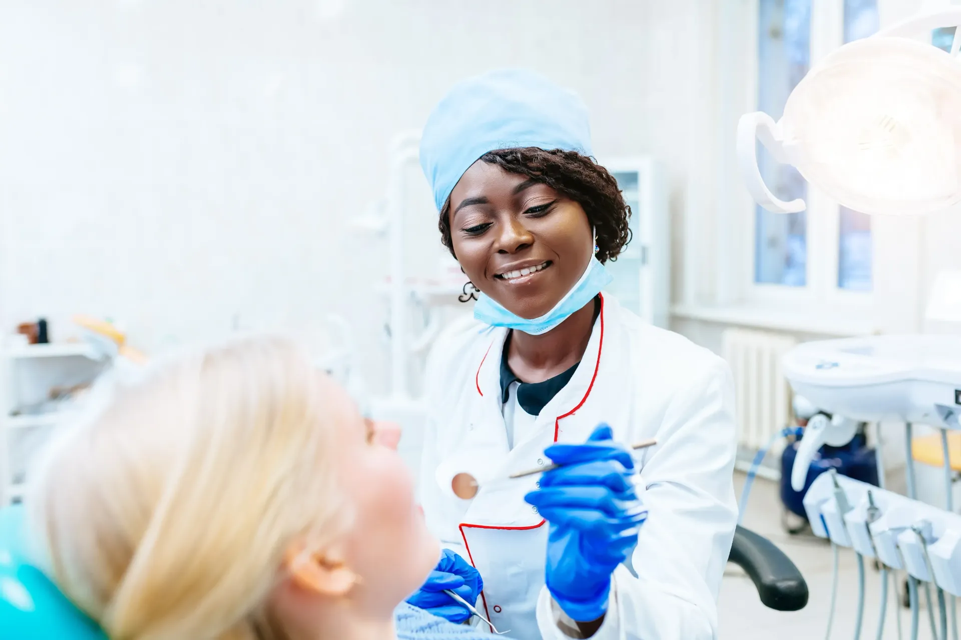 A female dentist is examining a patient 's teeth in a dental office.