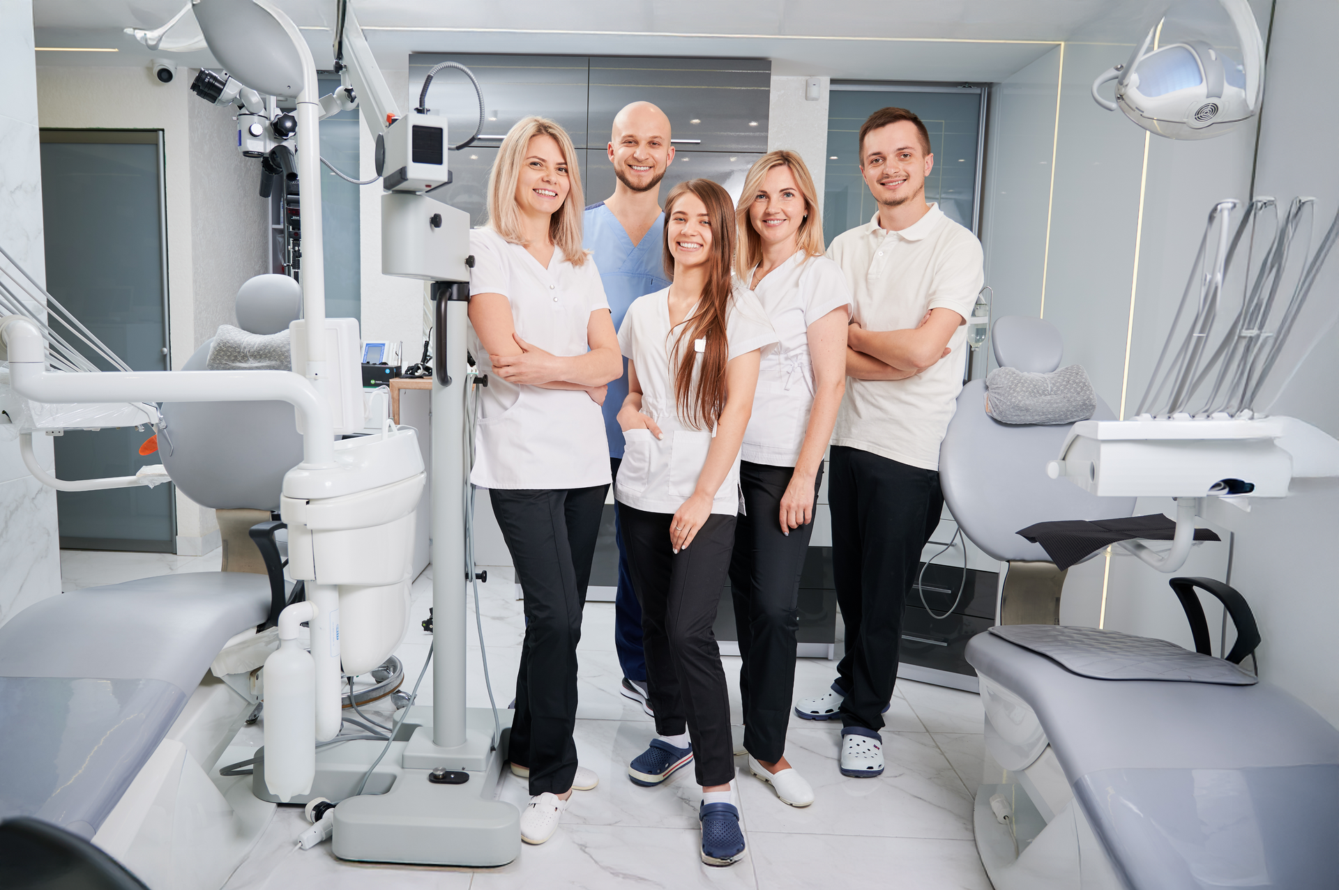 A group of dentists are posing for a picture in a dental office.
