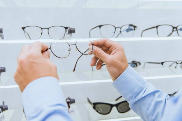 Man selecting eyeglasses from shelves at Pal Optical in Georgetown, KY, showcasing a variety of stylish and quality frames.