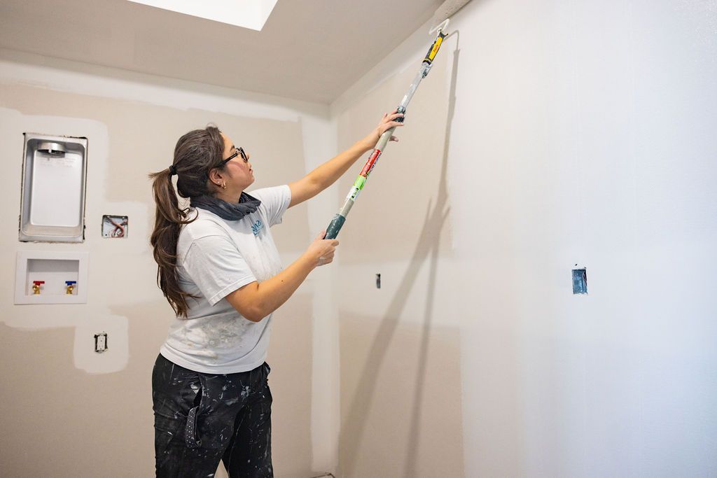 applying two coats of paint on wall