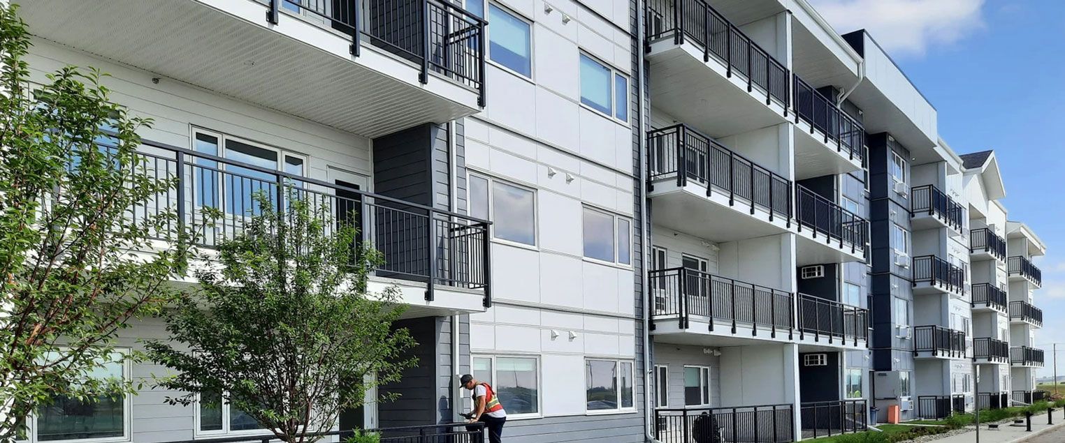 An image of a large community rental unit with newly painted exterior and scenic balconies overlooking natural surroundings.