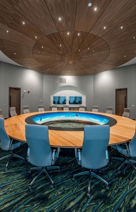 The renovated Kahkewistahaw Conference Centre Boardroom adorned with vibrant lighting, a stylish ceiling fixture, and newly painted walls.
