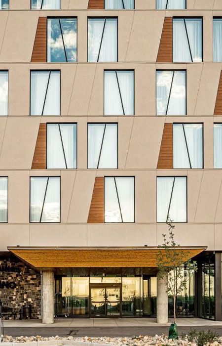 Renovated exterior of Dakota Dunes Hotel featuring windows and geometric wood panel accents