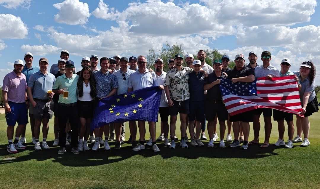 This image shows Team Europe and Team USA holding their respective flags at the Preconstruction Ryder Cup 2026 tournament. 