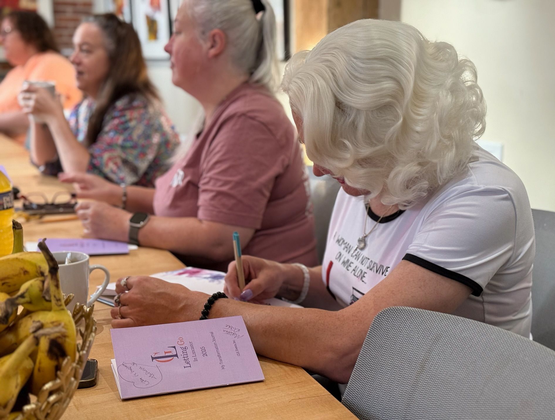 woman journaling and looking out a window