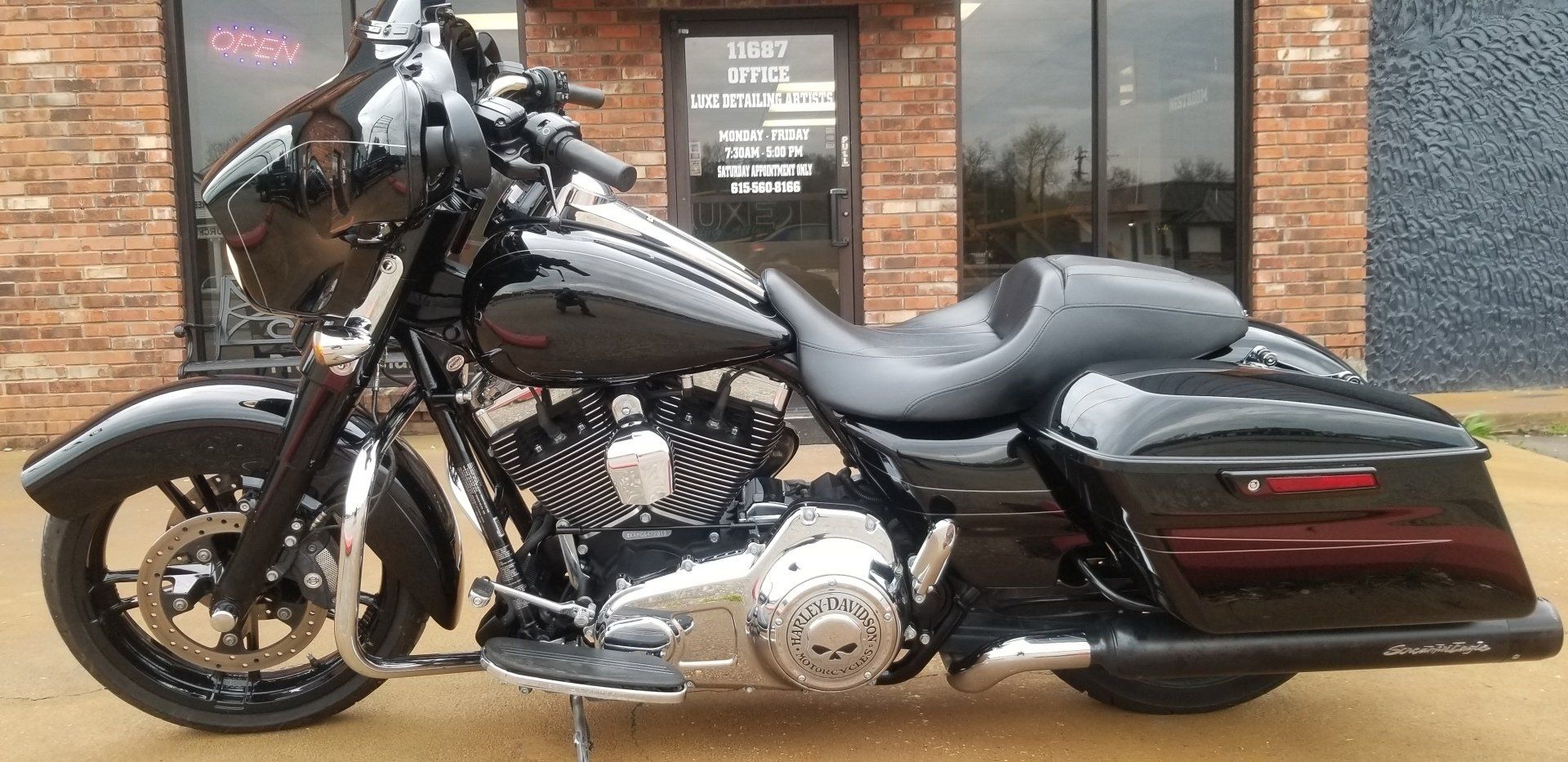 Black Harley-Davidson motorcycle parked in front of a building.