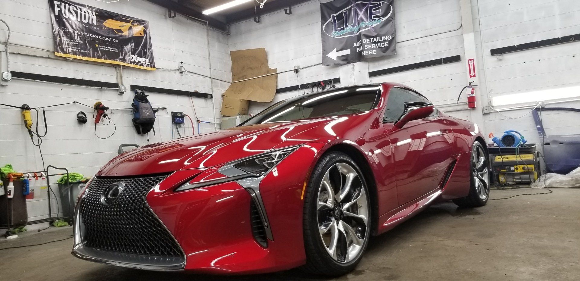 A shiny red Lexus sports car parked inside a garage.