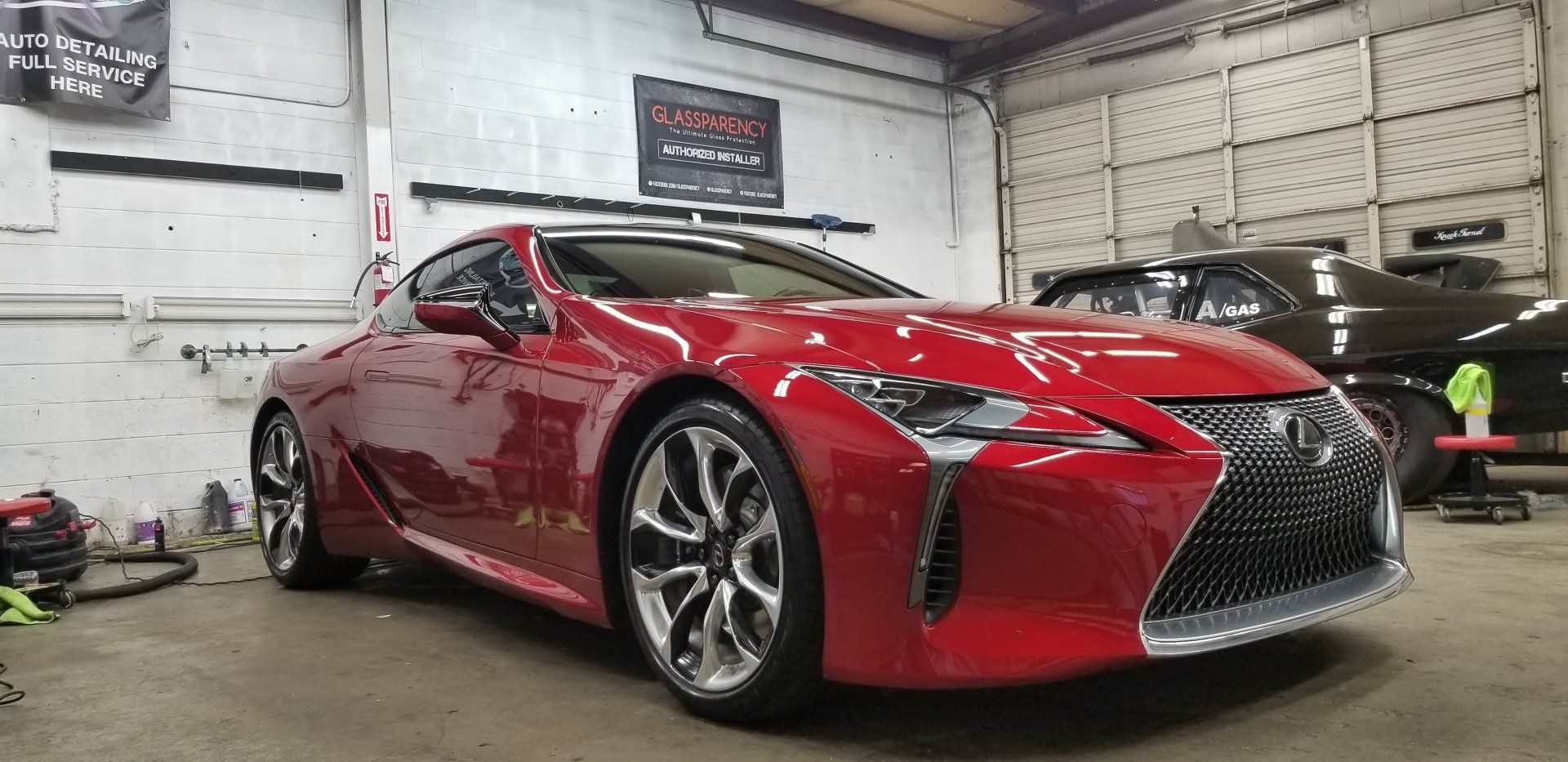 Red Lexus coupe in a garage.