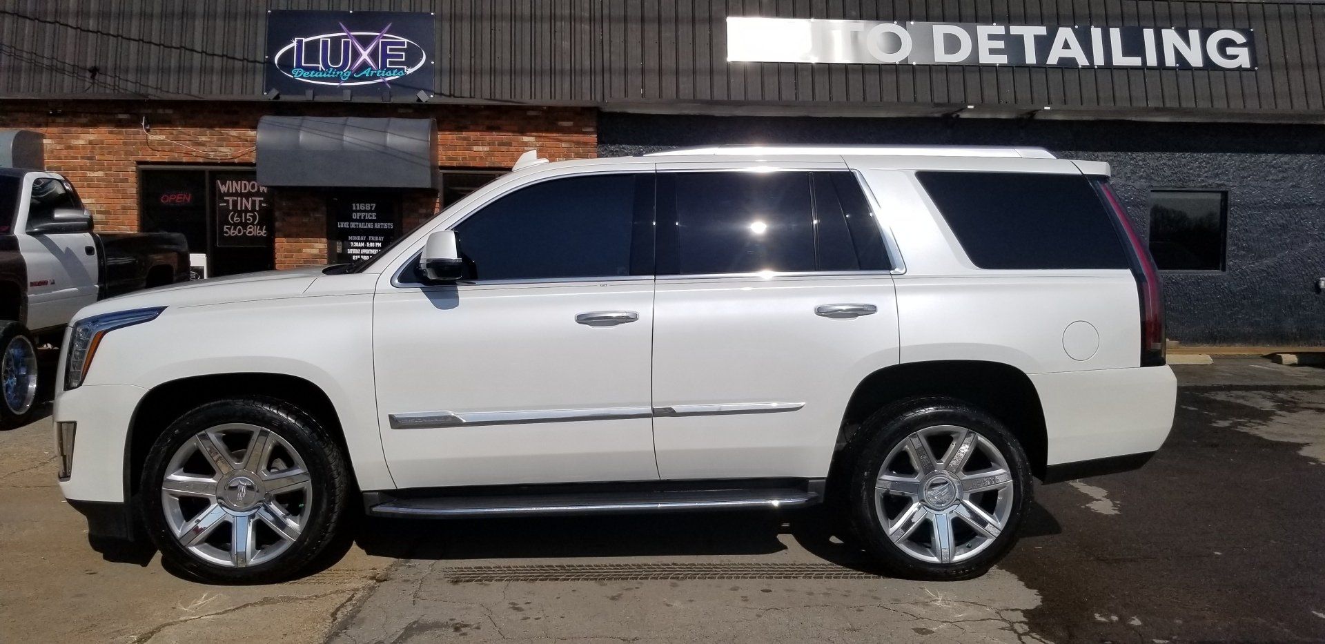 White SUV parked in front of a business with 