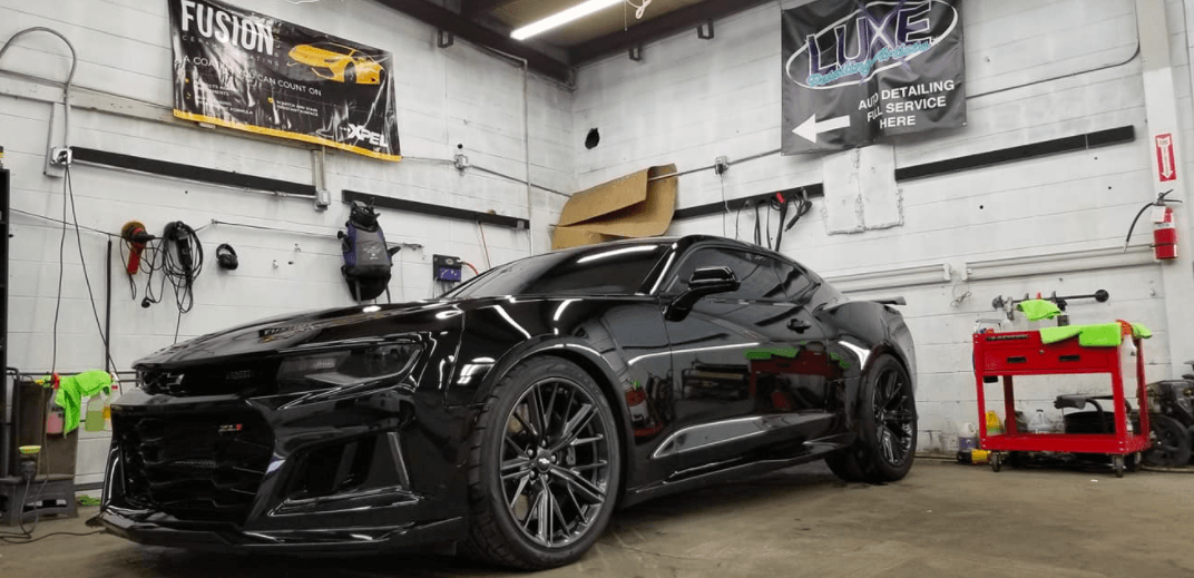 Black sports car inside a garage.