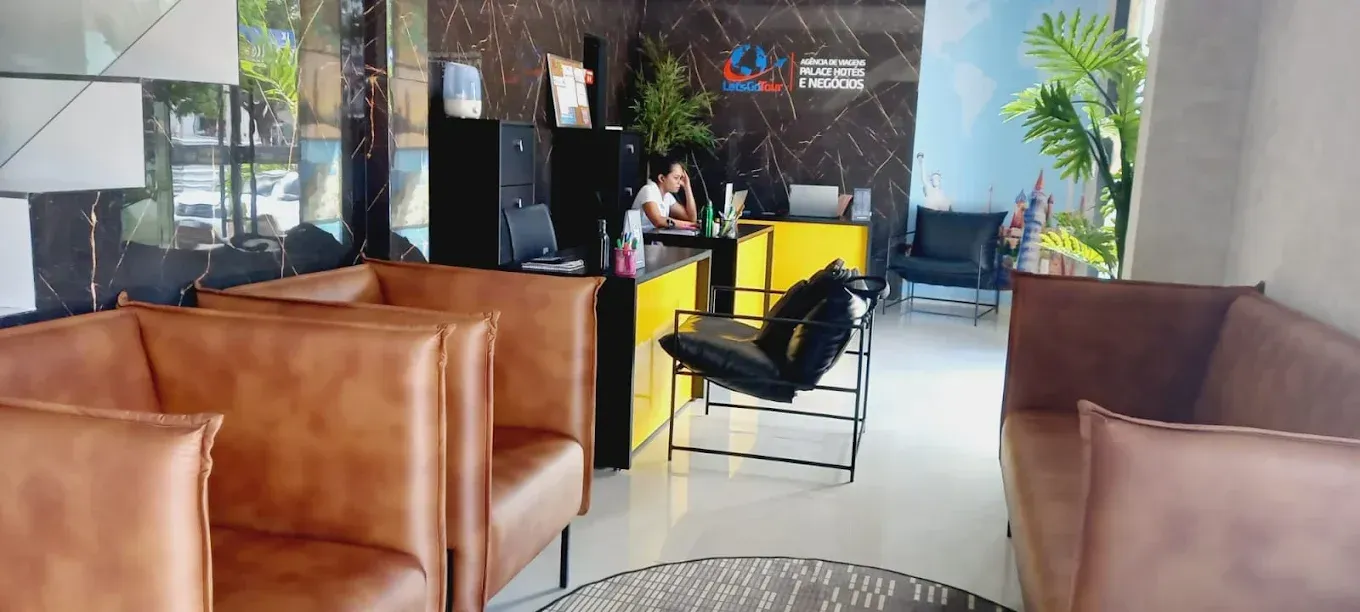 Uma sala de espera com cadeiras de couro marrom e um sofá.