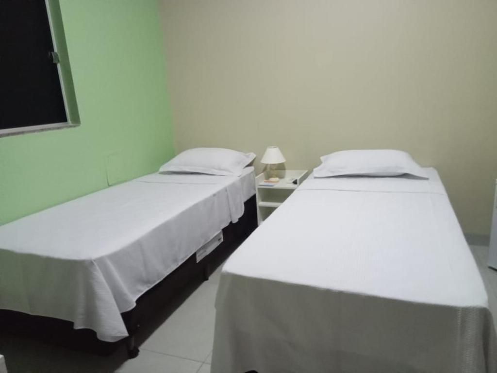 Um quarto com duas camas e uma mesa de cabeceira