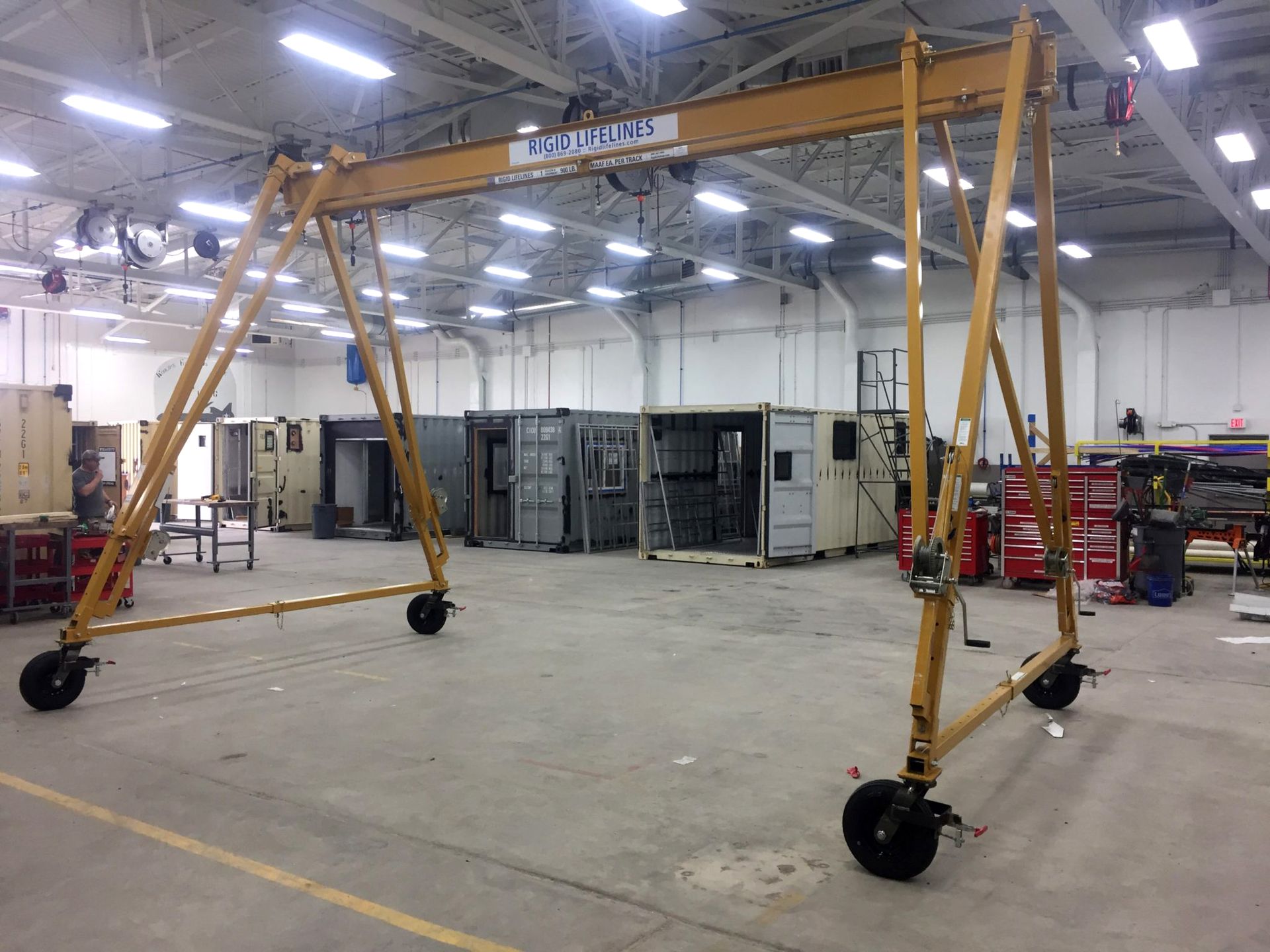 A large crane is sitting in the middle of a large warehouse.