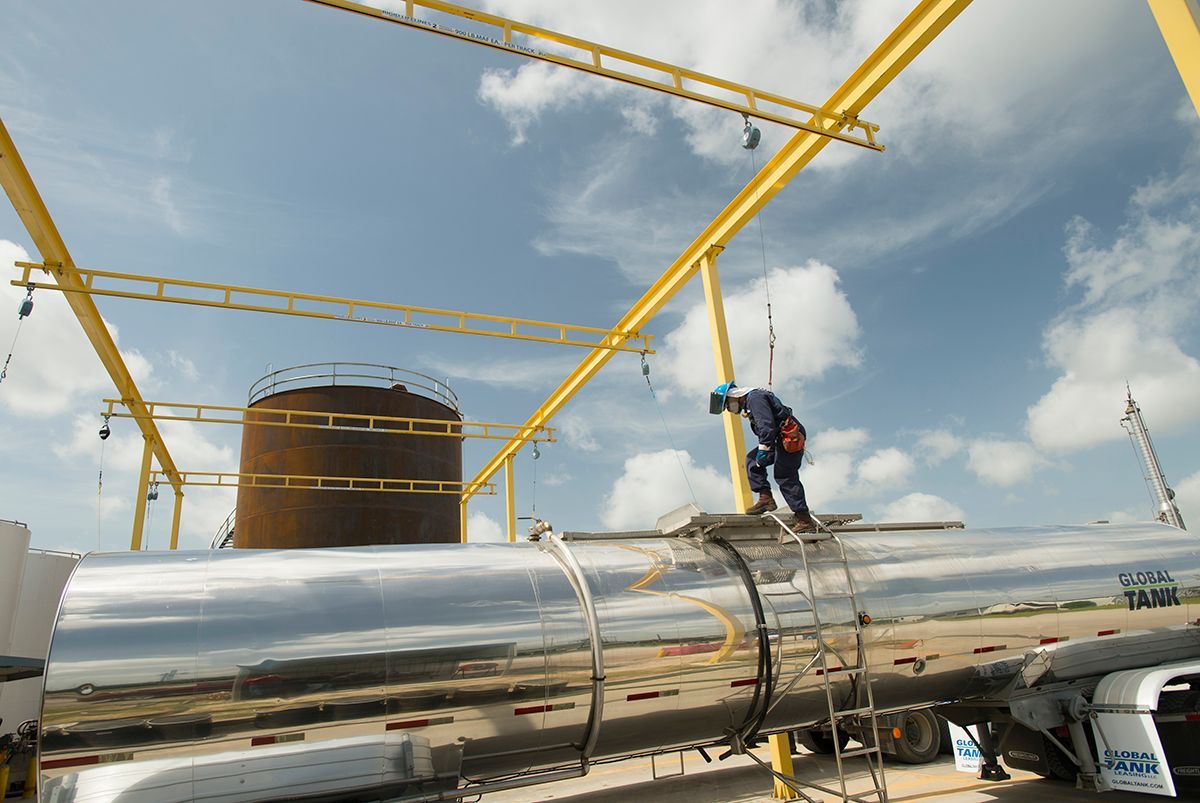 A man is working on a large pipe in a factory.