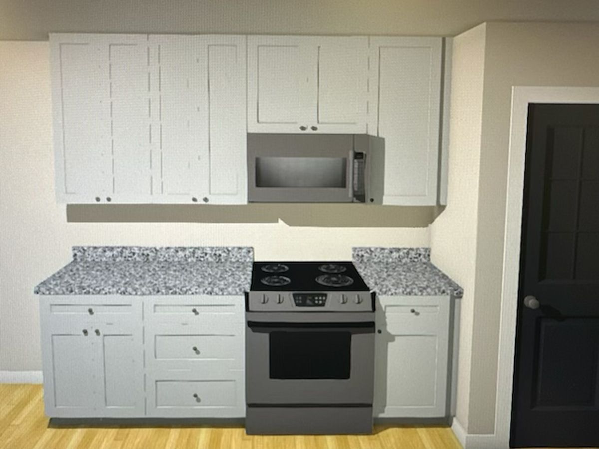 A kitchen with white cabinets and a stove and microwave