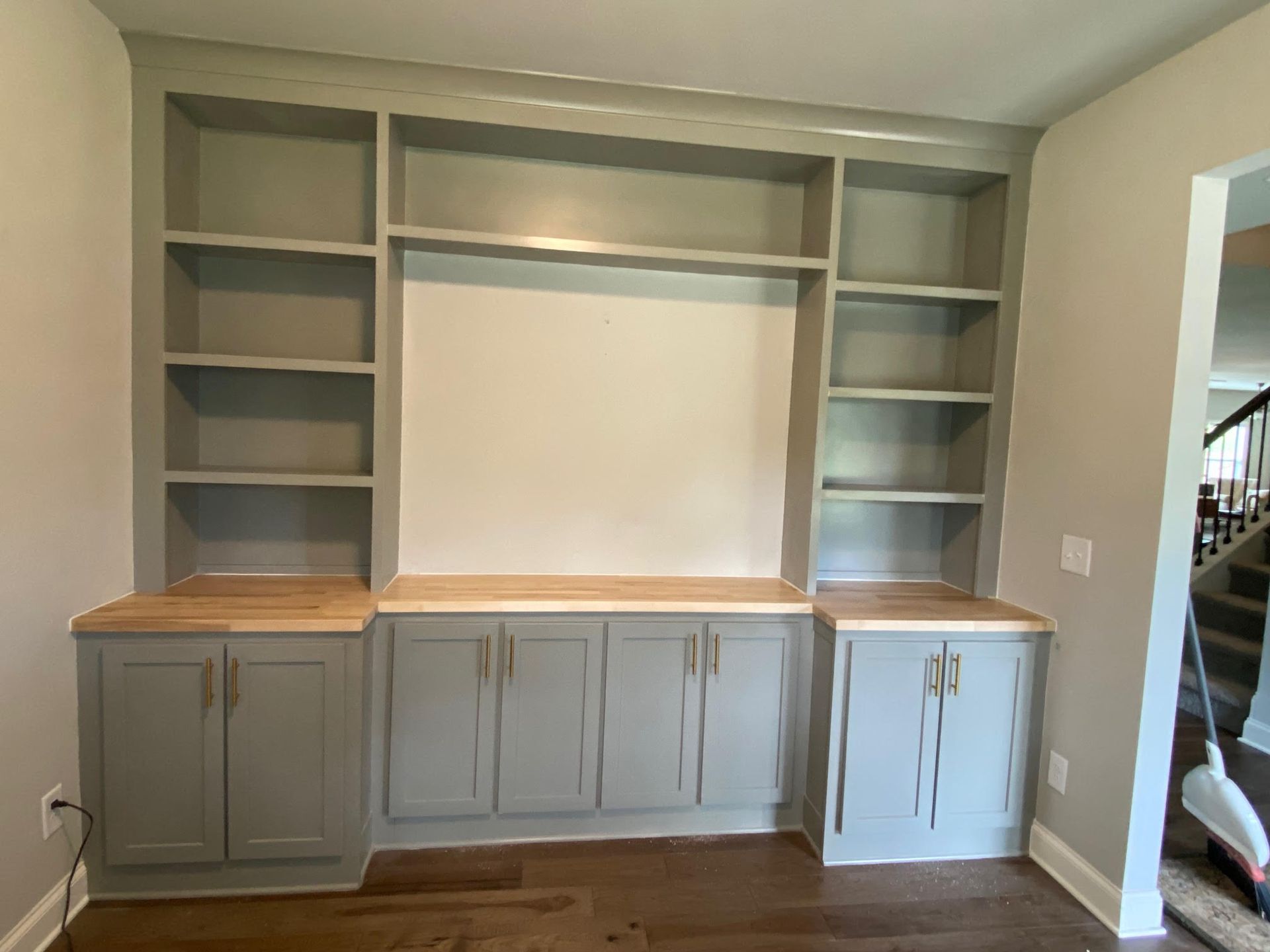 A living room with a lot of shelves and cabinets.
