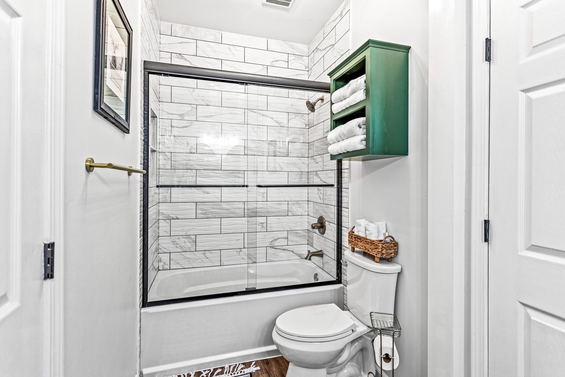 A bathroom with a toilet , bathtub and shower.