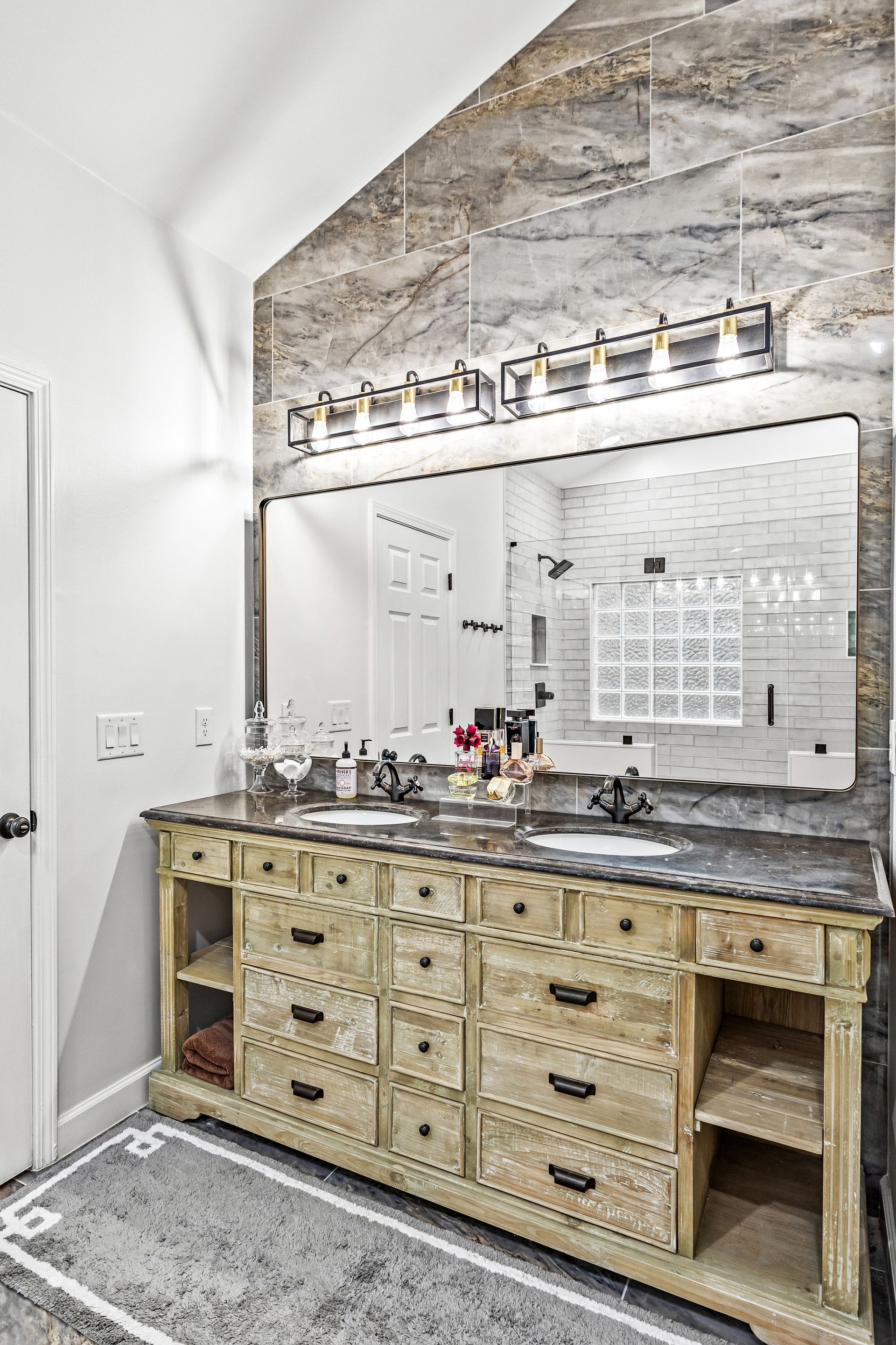 A bathroom with two sinks and a large mirror.