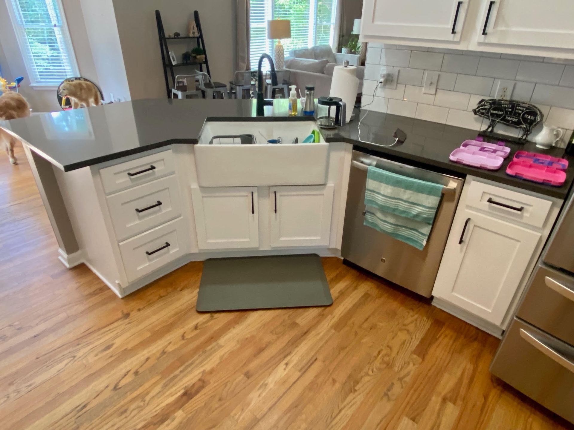 A kitchen with white cabinets , stainless steel appliances , a sink and a dishwasher.
