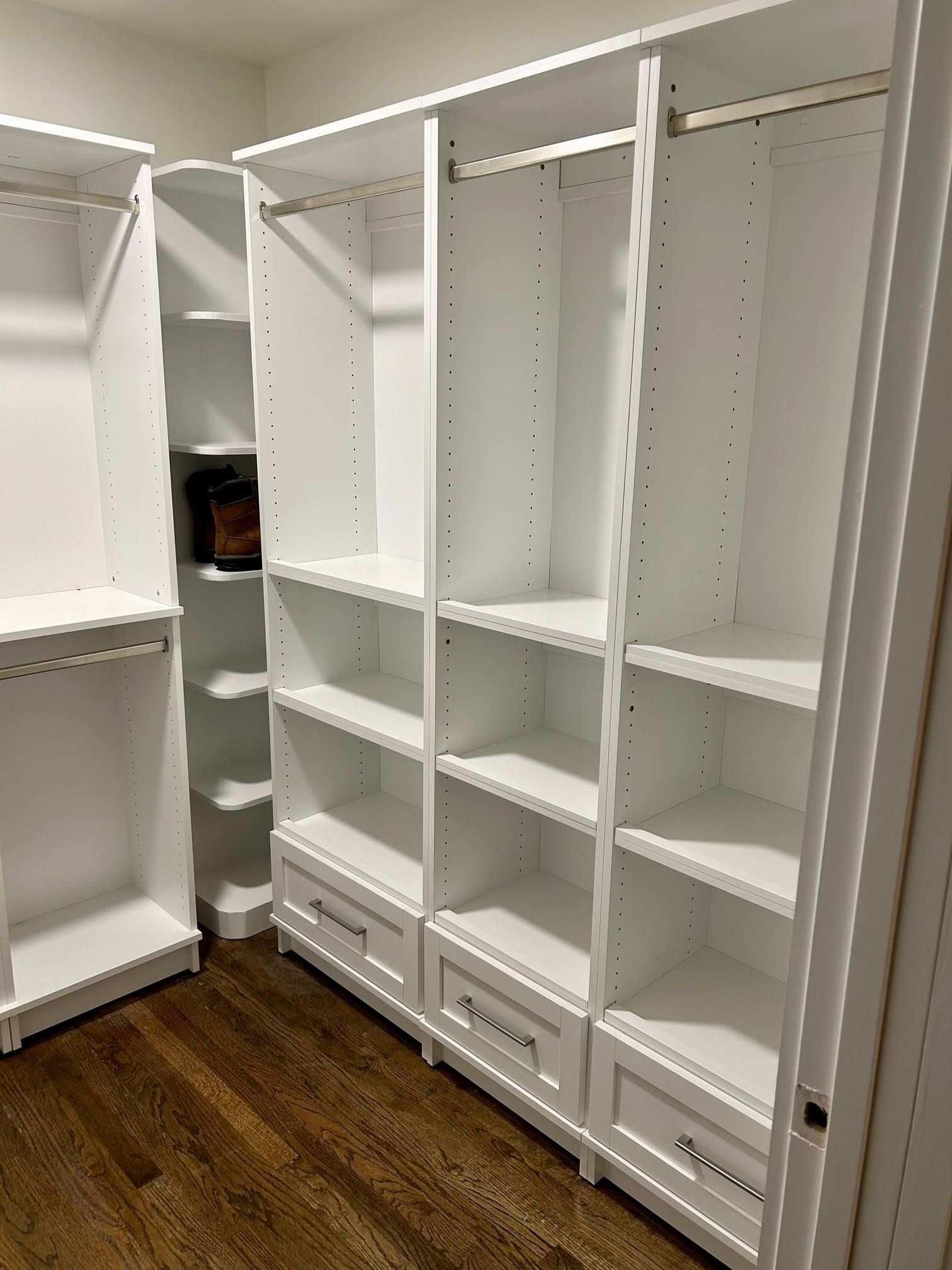 A walk in closet with lots of shelves and drawers.