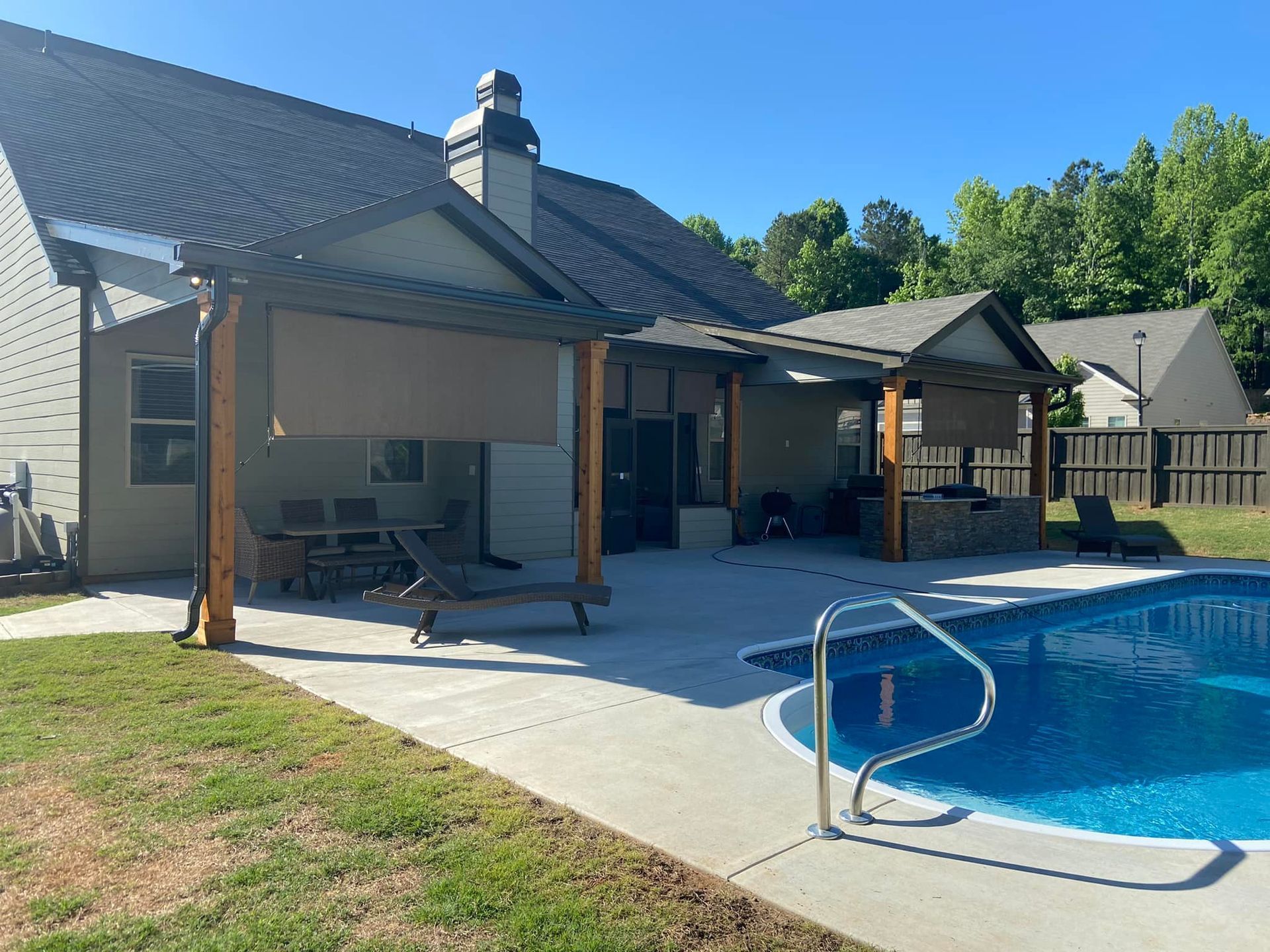 There is a large swimming pool in the backyard of a house.