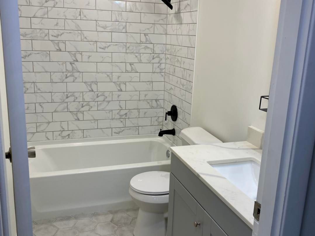 A bathroom with a toilet , sink and bathtub
