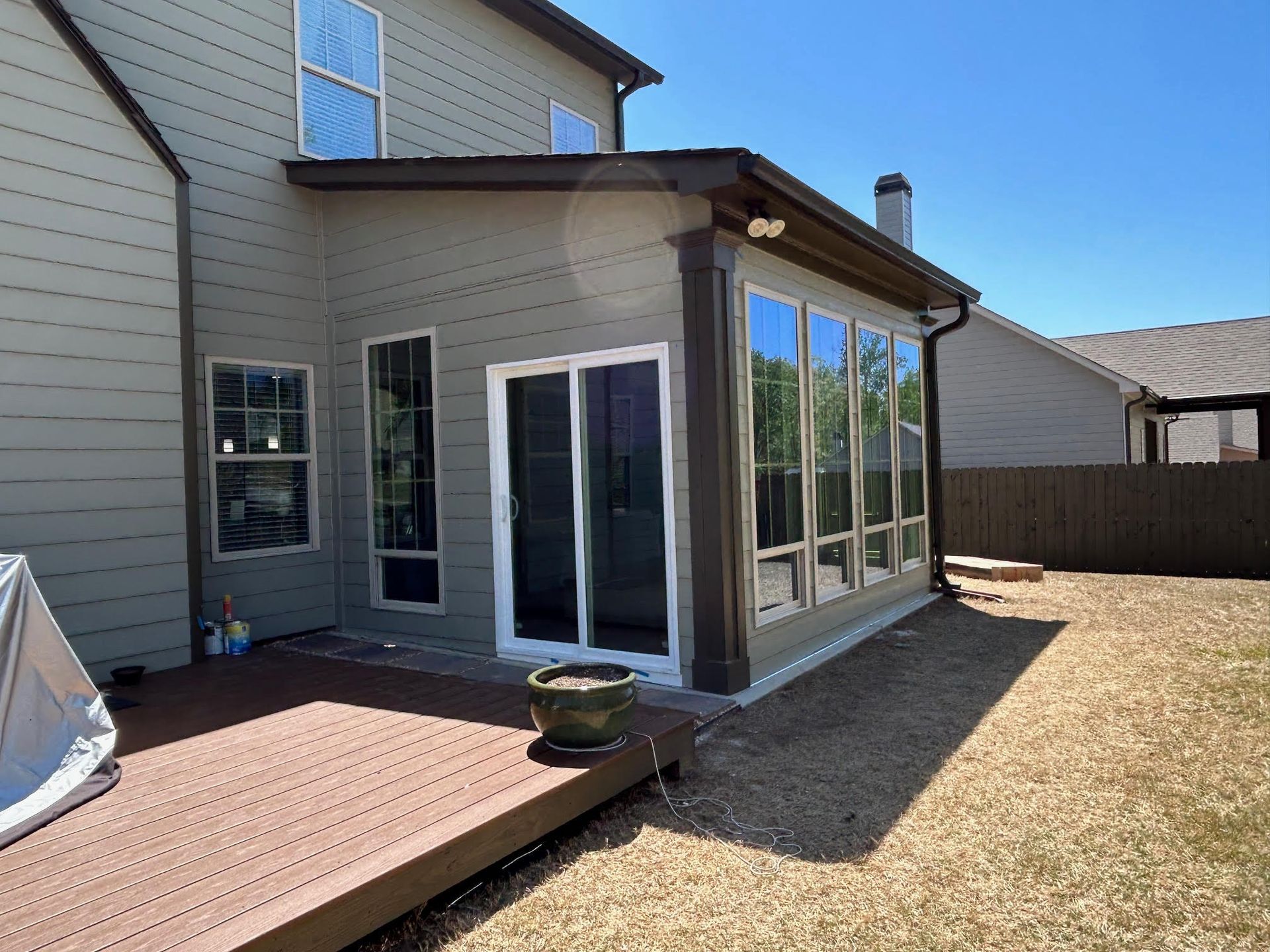 The back of a house with a deck and sliding glass doors.