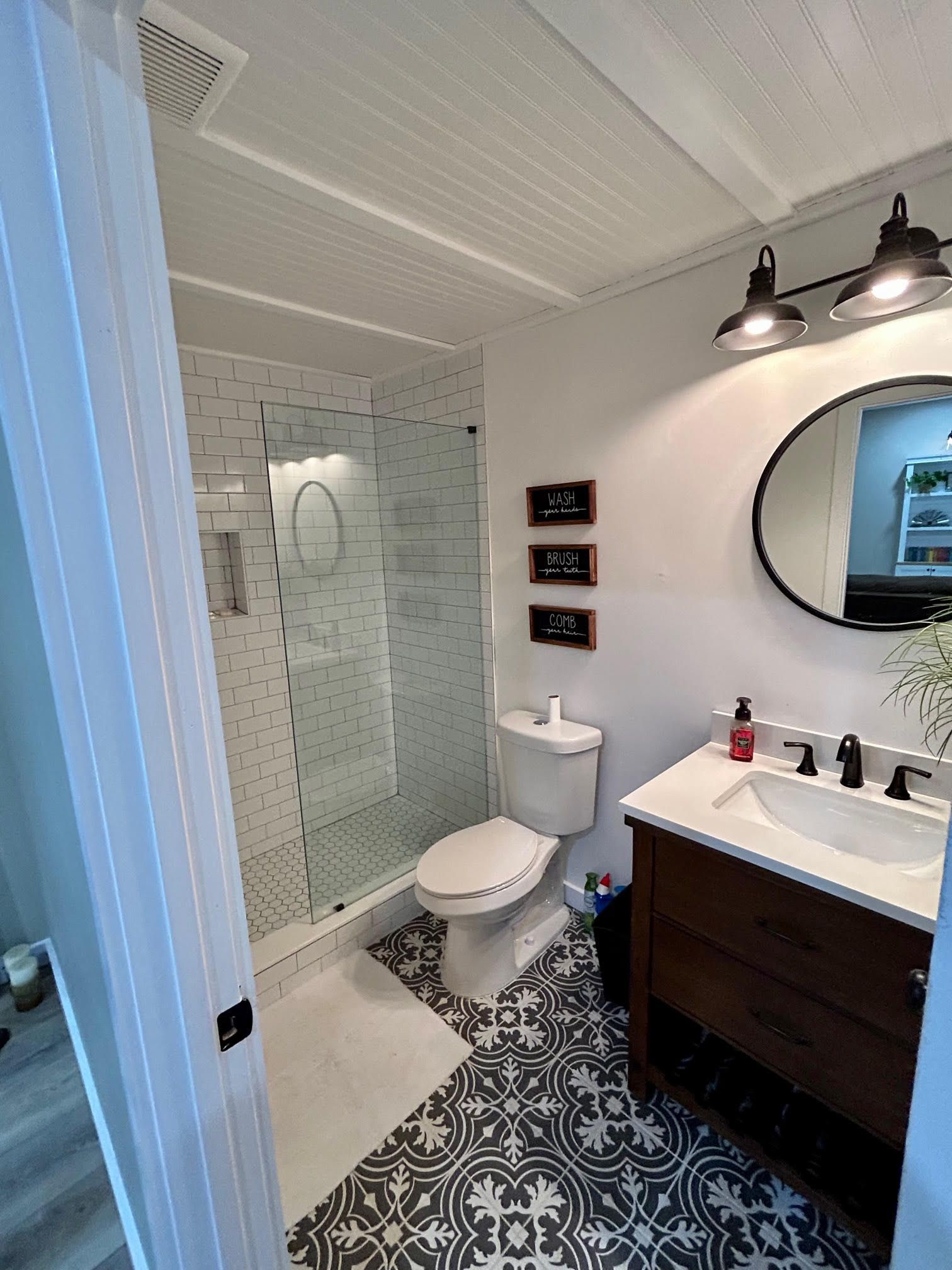 A bathroom with a toilet , sink and shower.